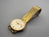an image of a gold watch on a table
