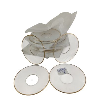 a stack of white plates with gold rims and napkins