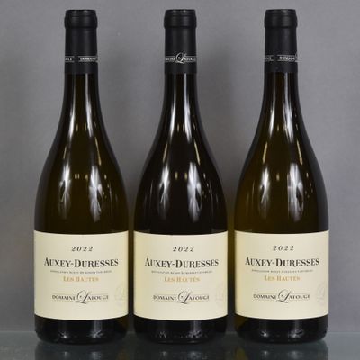 three bottles of wine are lined up on a table