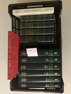 une pile de livres posée sur une étagère à côté d'une bibliothèque