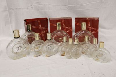 six flacons de parfum posés les uns à côté des autres sur une surface blanche