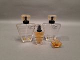 two bottles of perfume sitting next to each other on a table