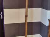 a coat rack in the corner of a room with a striped wall
