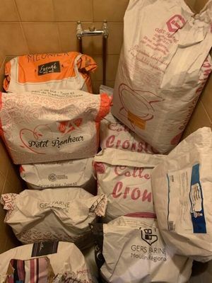 plusieurs sacs de nourriture dans une boîte posée par terre