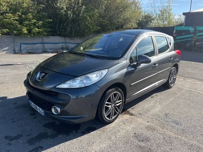 La petite voiture grise est garée sur le parking.