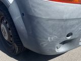 a car that has been dented and is parked on the side of the road