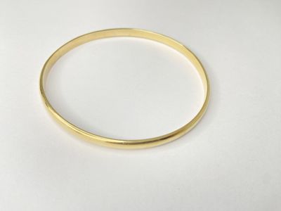a close up of a gold ring on a white surface
