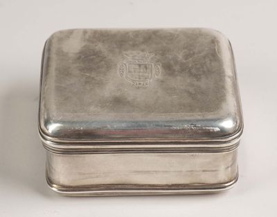 une vieille boîte en argent avec un couvercle en argent, posée sur une surface blanche