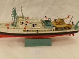 une maquette de bateau exposée sur une surface blanche