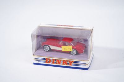 une petite voiture rouge dans une boîte sur une surface blanche