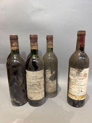 four bottles of wine are lined up on a white surface