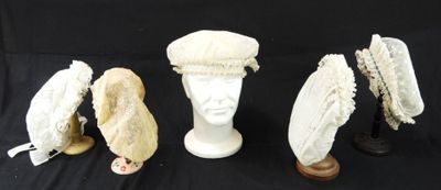trois chapeaux blancs et un porte-chapeaux sur fond noir
