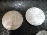 deux pièces d'argent posées l'une à côté de l'autre sur une surface noire