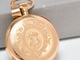 an image of a close up of a gold pocket watch on a white surface