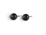 une paire de boucles d'oreilles à clous noires et dorées sur fond blanc