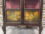 a cabinet with two paintings on it and a stone wall in the background
