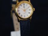 une image d'une montre en or avec des chiffres romains sur le cadran