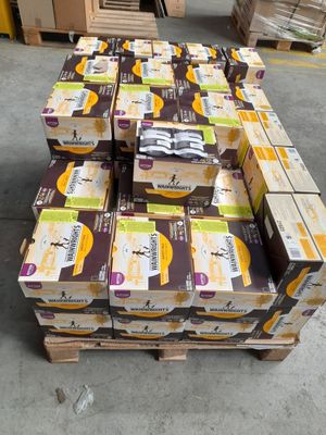 Plusieurs cartons de denrées alimentaires sont empilés sur une palette dans un entrepôt