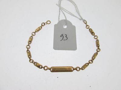 Gros plan sur un bracelet en or portant une étiquette