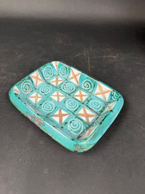 a small blue and white plate on a black table