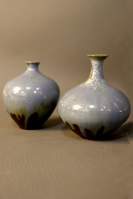deux petits vases posés l'un à côté de l'autre sur une table
