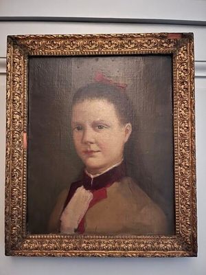 portrait d'une femme vêtue d'un manteau marron et d'un nœud papillon rouge