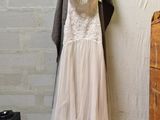 a wedding dress hanging on a clothes rack in a room