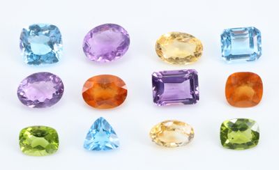 un ensemble de sept pierres précieuses de couleurs différentes sur un fond blanc