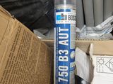 une bombe de mastic bleu à côté d'une boîte en carton
