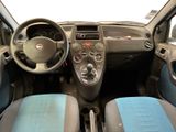 the interior of a small car with blue seats and a steering wheel