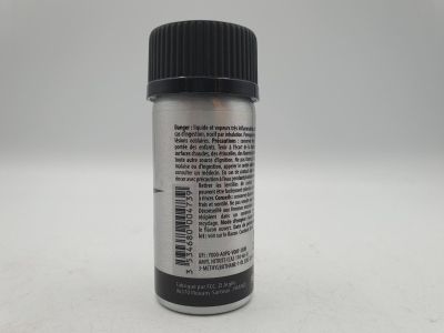 un gros plan sur un flacon de peinture argentée posé sur une surface blanche