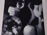 a black and white photo of a woman holding a glass of wine