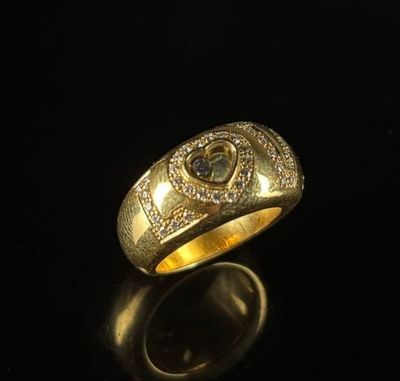 gros plan d'une bague en or avec des diamants sur une surface noire