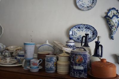 de nombreuses assiettes et tasses posées sur une étagère dans une pièce