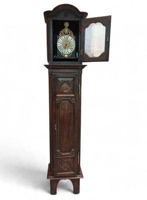 une grande horloge de parquet en bois surmontée d'un miroir