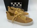 a pair of tan sneakers with white soles and a black box