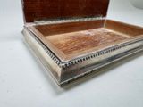 a silver box with a wooden lid on a white table