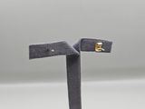 a close up of a pair of earrings on a stand
