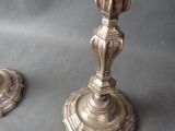 pair of antique brass candlesticks on a grey background