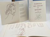 two open books with drawings on them on a table