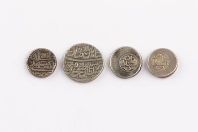 four different types of coins sitting on top of a white surface