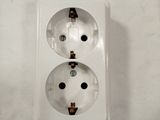 a white electrical outlet with two black dots on it