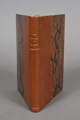 an old book sitting on top of a table next to a white wall