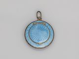 un gros plan d'un petit pendentif bleu sur une surface blanche