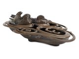 une sculpture en bronze représentant un bateau sur lequel se trouvent des oiseaux