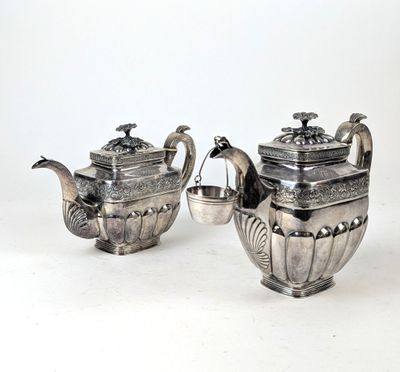 deux théières en argent et une théière sur fond blanc