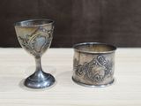 une coupe en argent et une autre coupe en argent posées sur une table