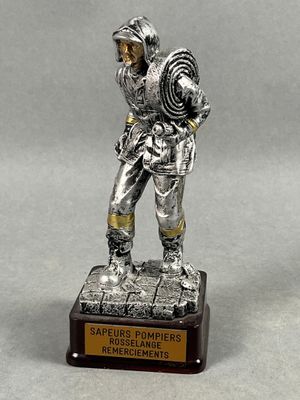 Trophée de pompier représentant un soldat du feu, casqué, la…