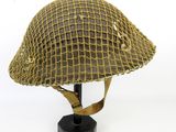 une image représentant un casque militaire posé sur un support, sur fond blanc