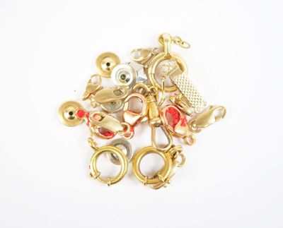 a pile of gold charms on a white surface